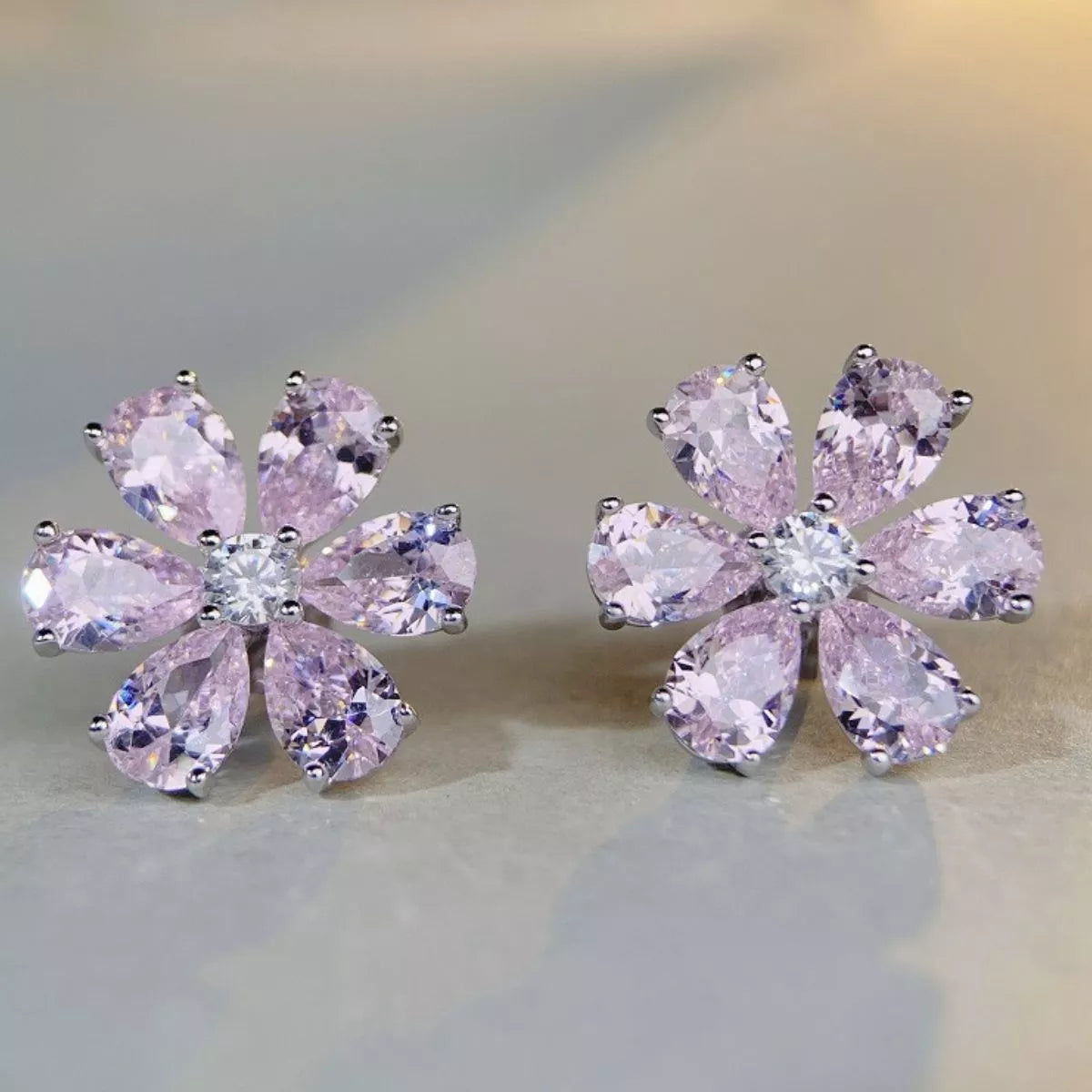 Pair of pink flower stud earrings with teardrop-shaped petals and clear centre stones