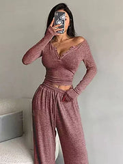Model wearing a rose-coloured button-detail cropped top and matching wide-leg pants in a mirror