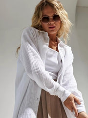 Model wearing a white textured gauze button-down shirt over a tank top.