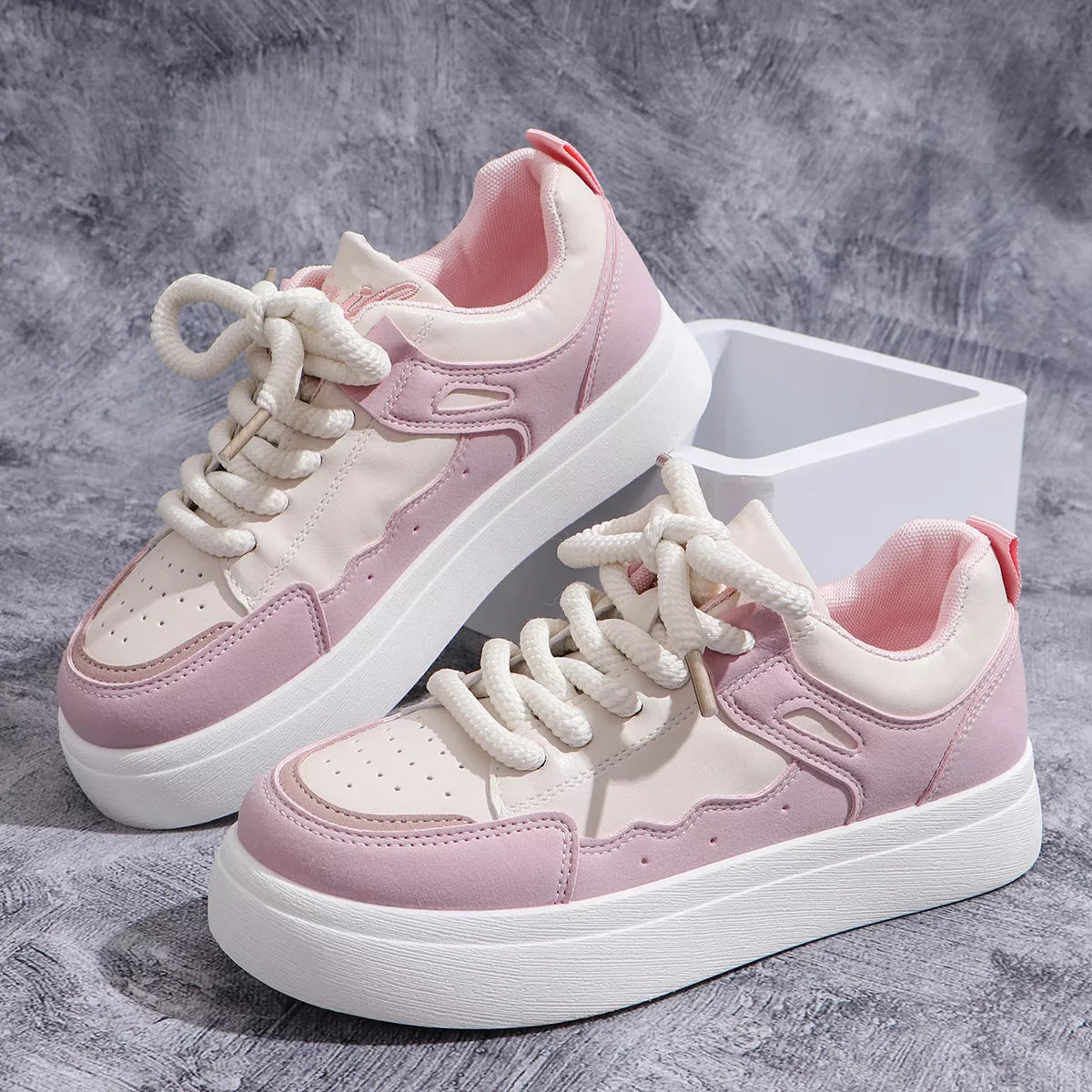 Pair of pink and white platform sneakers on display