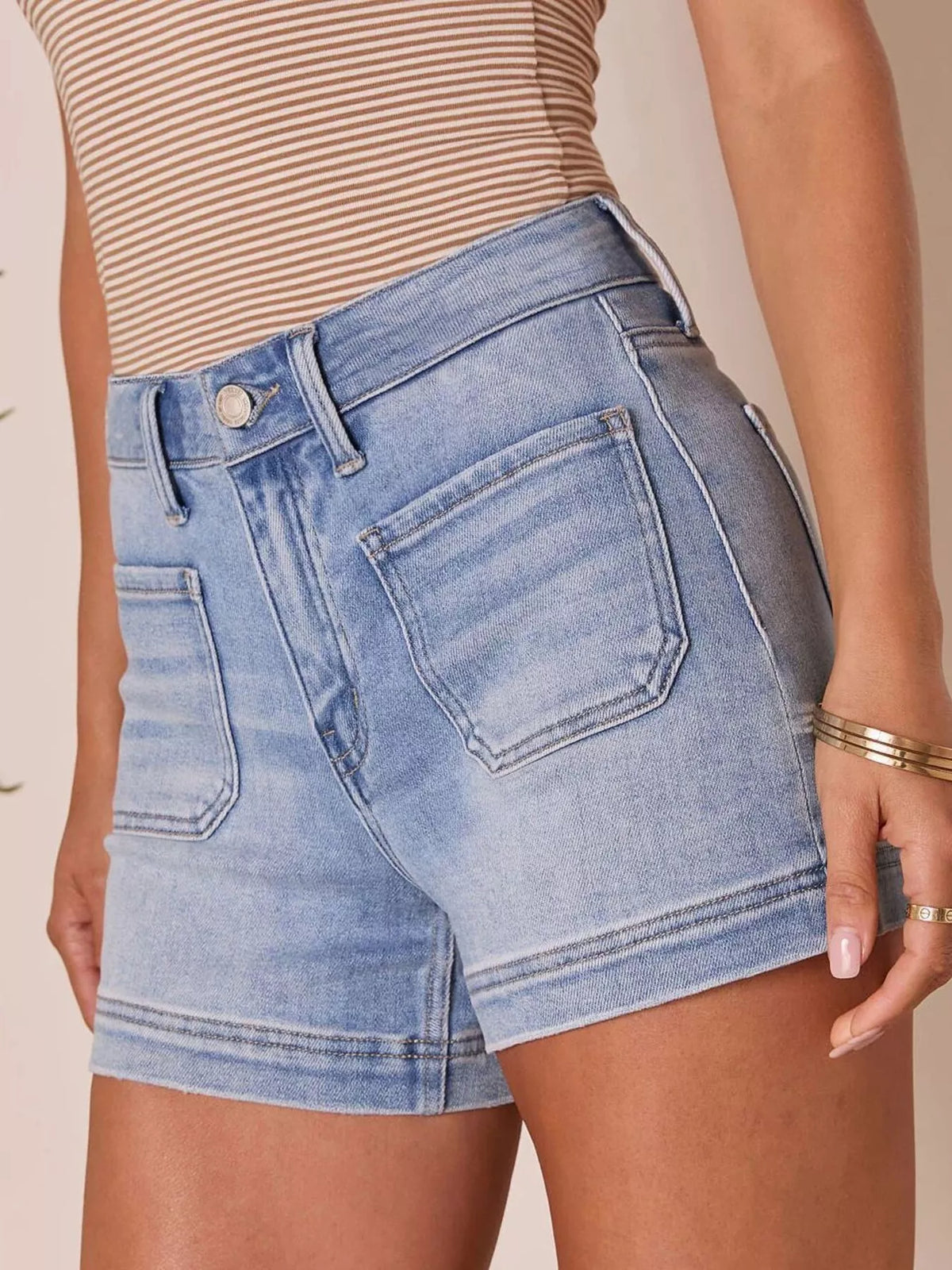 Light wash high-waisted denim shorts shown from the front with rolled cuffs.