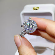 Close-up of round clear centre stone and silver ring held in hand