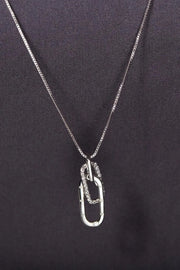 Silver-tone open rectangular pendant necklace on dark background