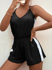 Close view of black romper neckline, elastic waist and side stripe