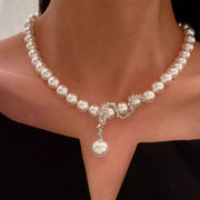 Front view of white pearl necklace with crystal floral center and pearl pendant