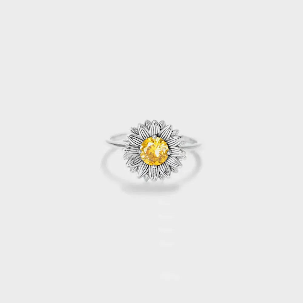 Silver-tone sunflower ring with a yellow center stone on white