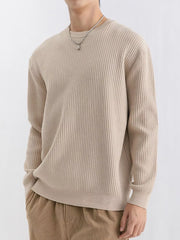 Angled view of beige ribbed crew-neck sweater with dropped shoulders