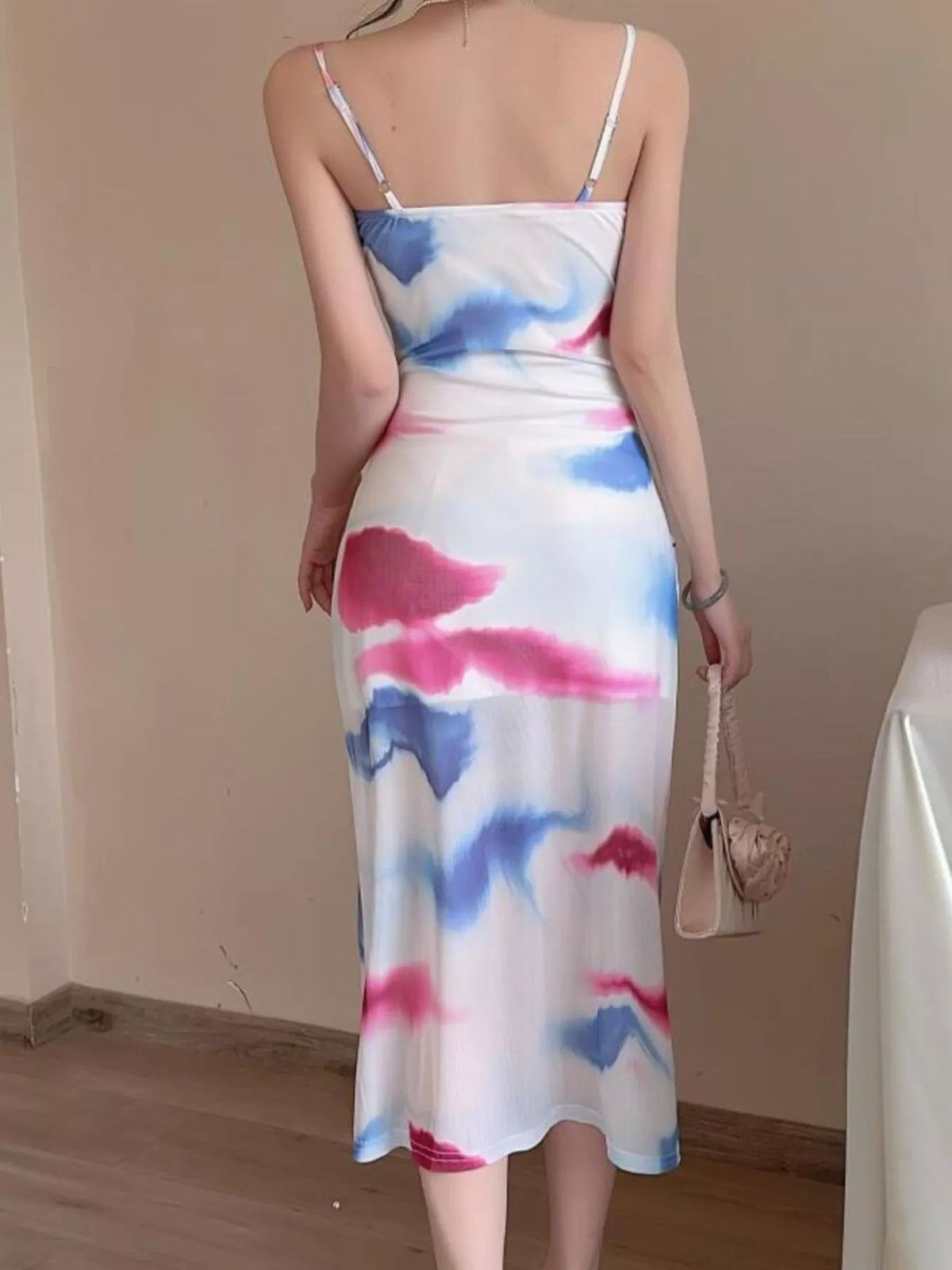 Back view of the pink-and-blue watercolor midi dress with narrow shoulder straps.