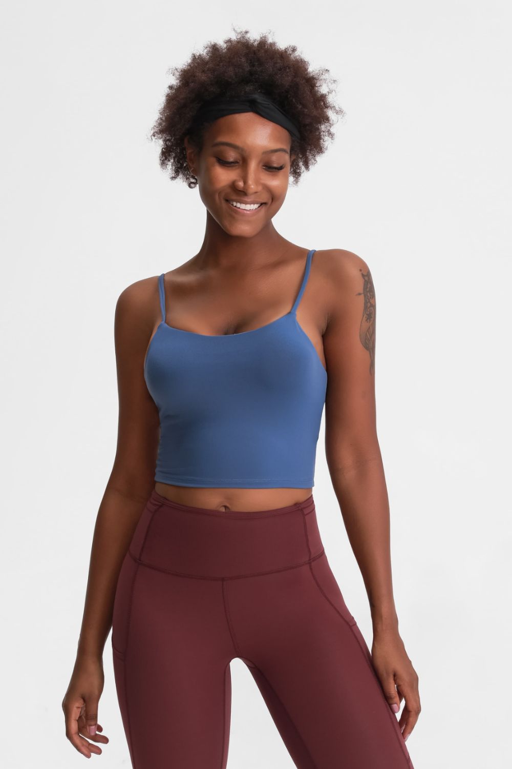 Model wearing a blue scoop-neck cami with burgundy leggings, front view.