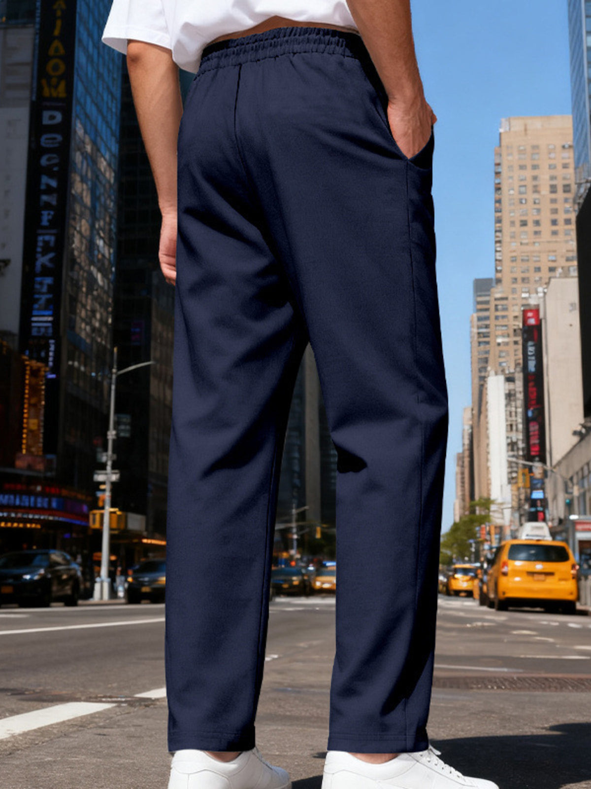 Back view of navy pants with elastic waist in a city street setting.