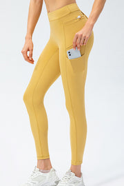 Side view of mustard yellow pocket leggings with phone in the thigh pocket