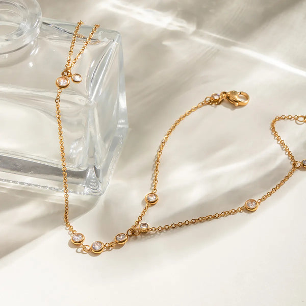 Gold hand chain with rhinestone accents laid out flat