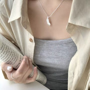 Model wearing a silver feather pendant necklace