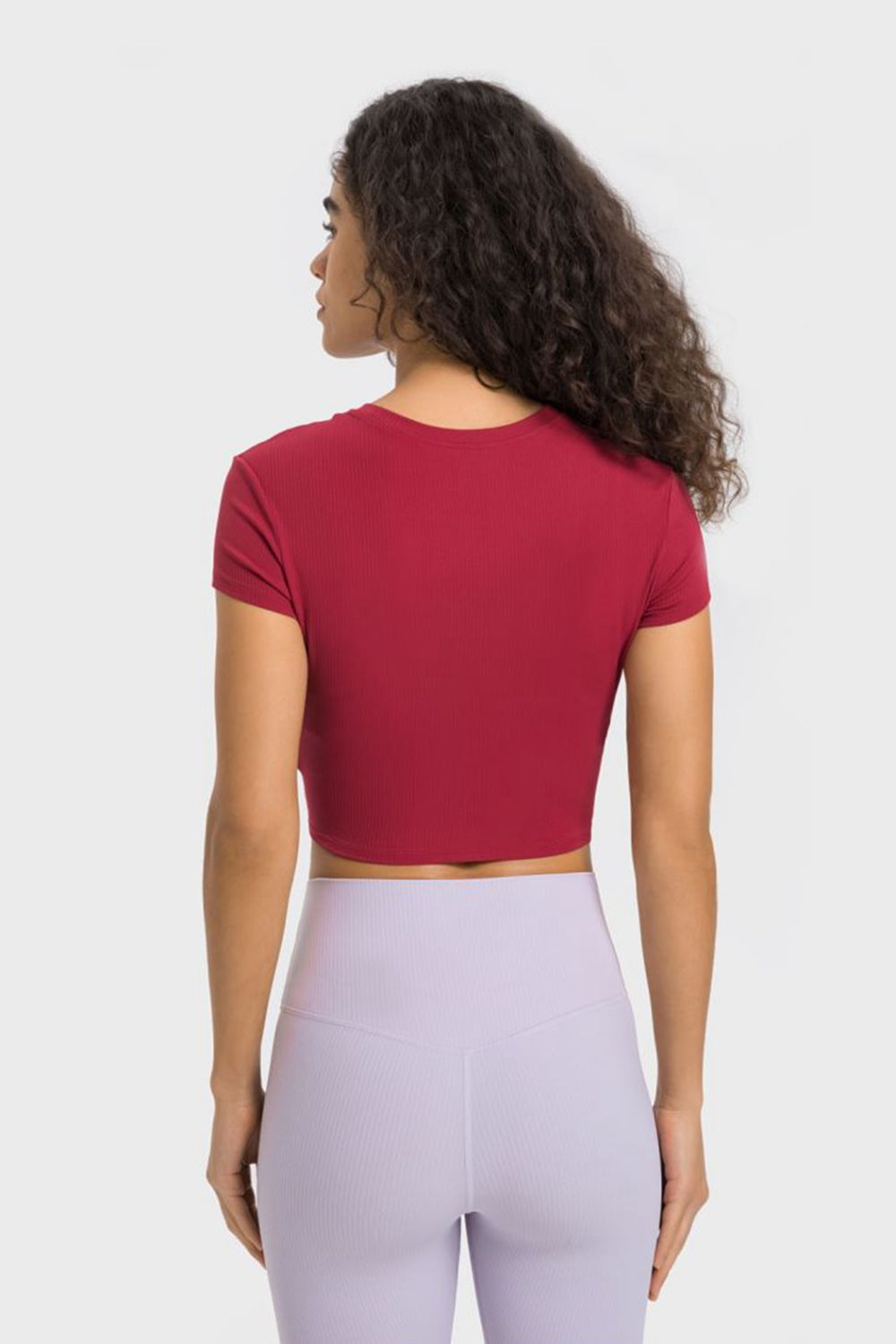 Back view of burgundy cropped T-shirt paired with lavender leggings