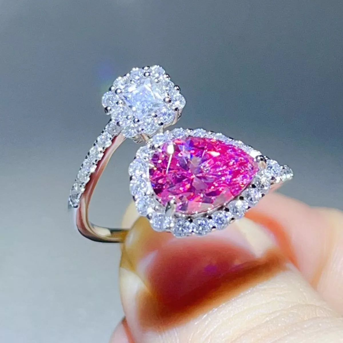 Close-up of pink pear-shaped centre stone with clear halo and cluster