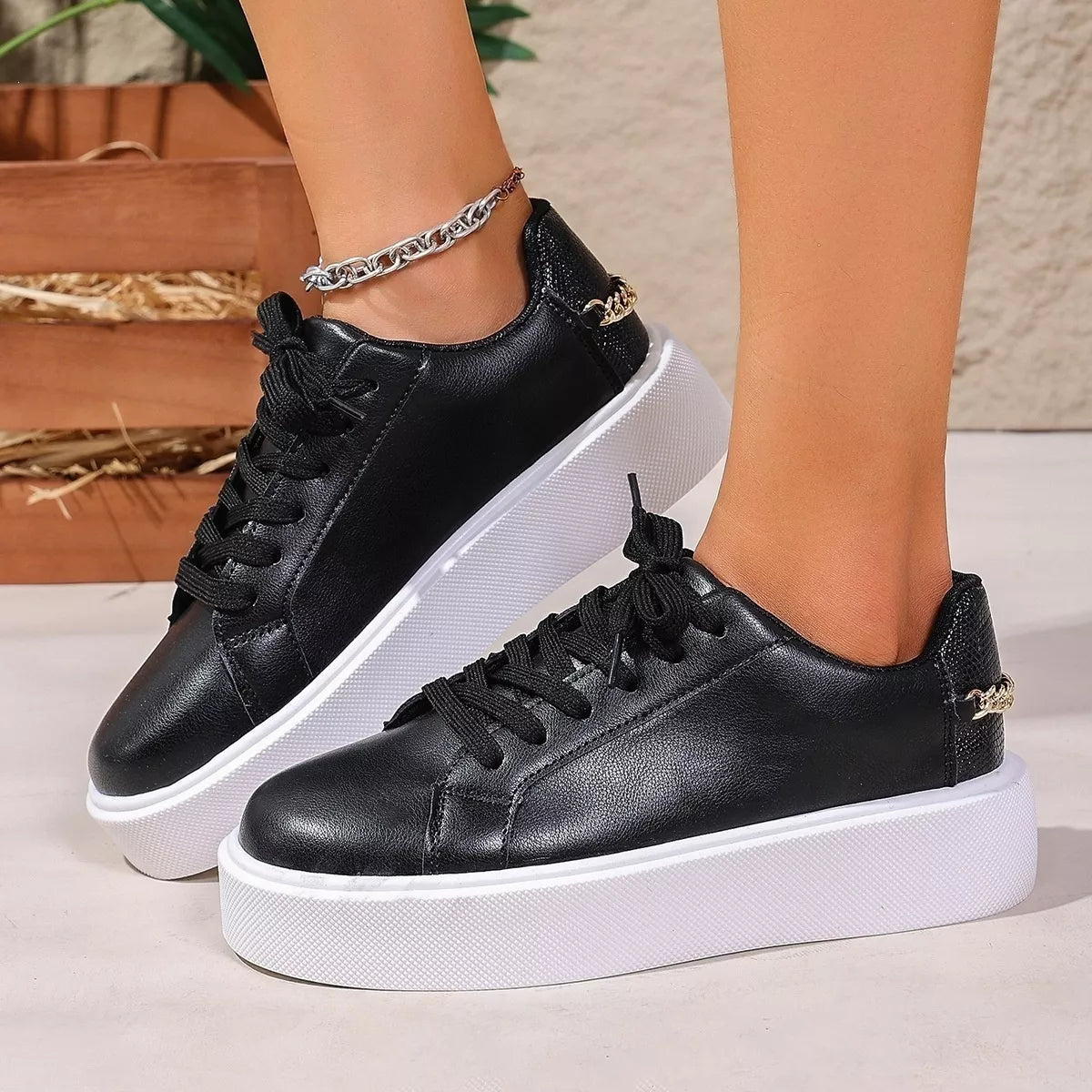 Pair of black lace-up platform sneakers worn with jeans
