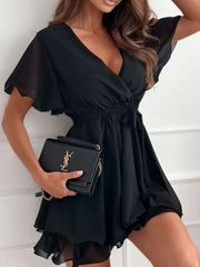 Model wearing black surplice flutter-sleeve mini dress