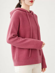 Side-front view of the dusty pink knit sweater showing the ribbed cuff and hem.