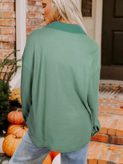 Back view of sage button-up shirt on model