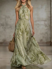 Front view of a sleeveless pale green chiffon maxi dress with an allover leaf print.