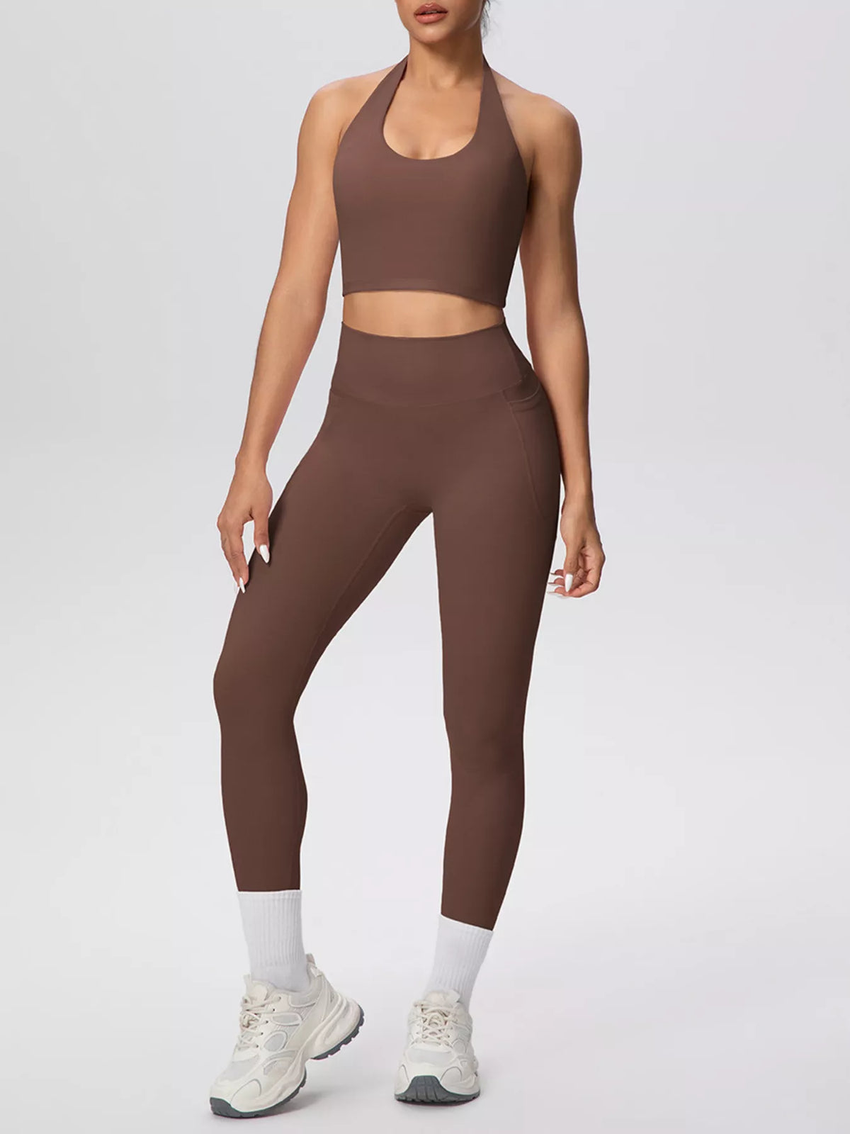 Front view of brown halter-neck crop top and high-waisted leggings