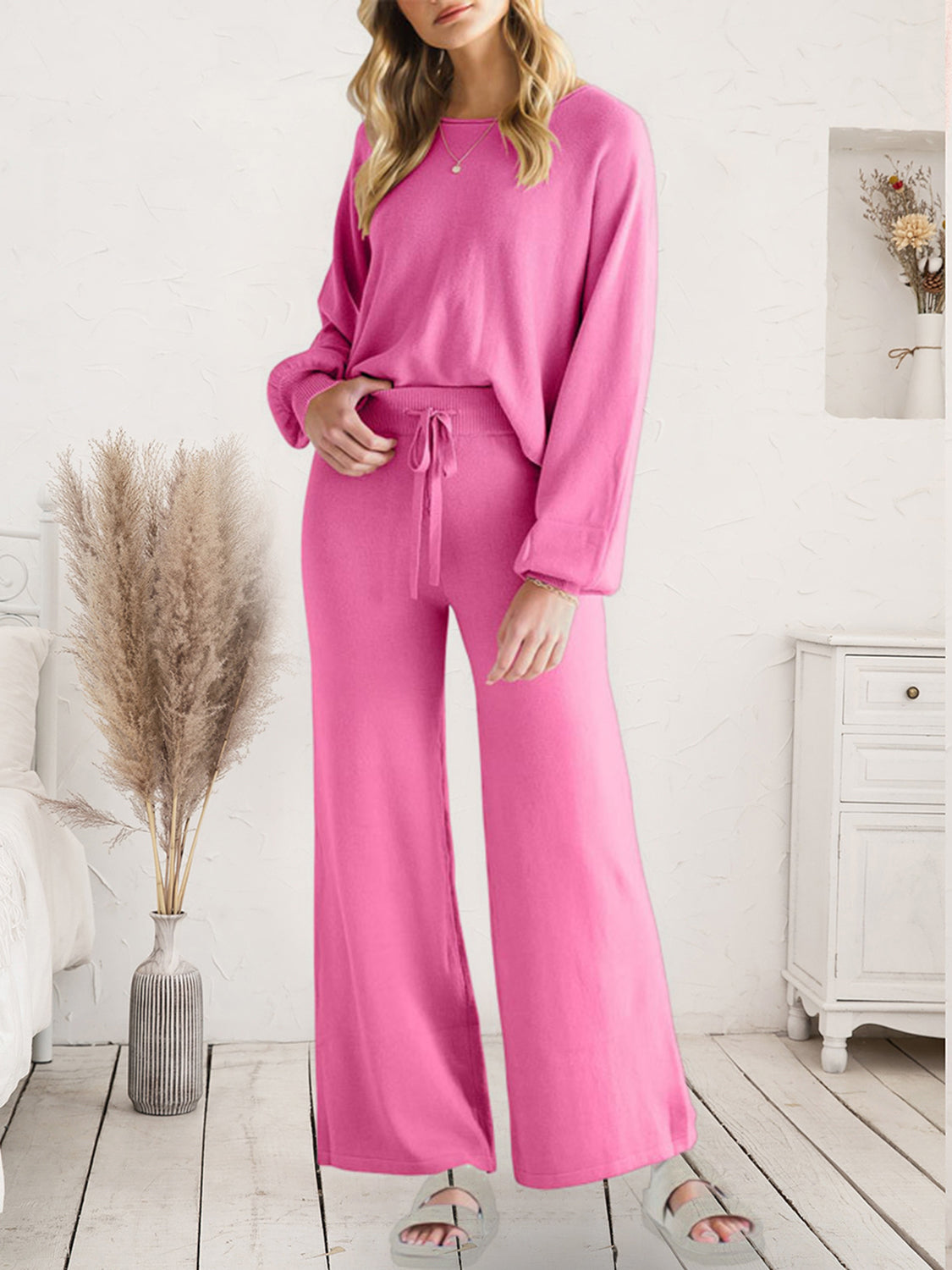 Model wearing pink long-sleeve lounge top and matching drawstring pants, front view