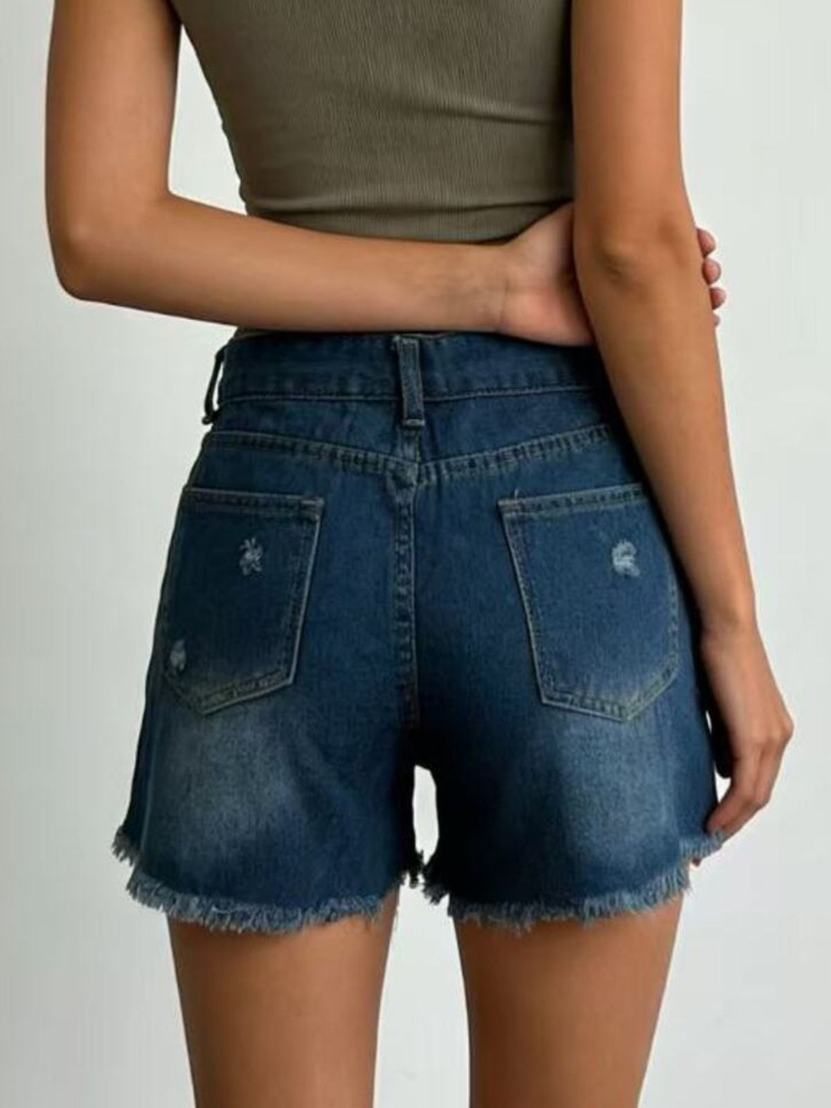 Back view of dark-wash denim shorts with distressed details