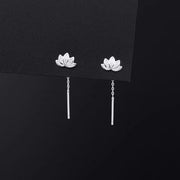 Front view of pair of lotus drop earrings on dark card
