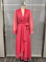 Front view of the pink long-sleeve wrap maxi dress with a waist tie on a dress form.