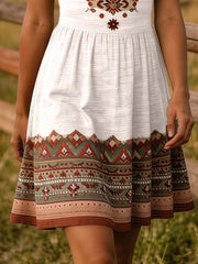 White dress with brown geometric print across the bodice