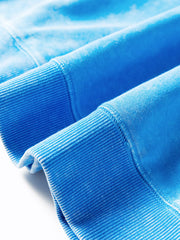 Women's mineral-wash blue raw-seam pocket sweatshirt, close-up of ribbed sleeve cuff