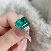 Close view of the green centre stone and side stones on the silver ring.