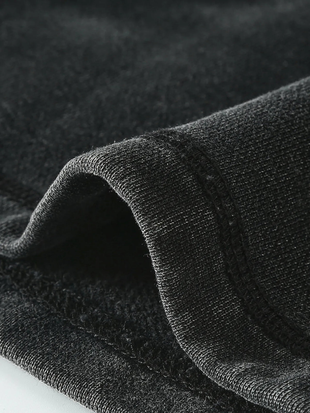 Close-up of the soft-looking black fabric draped at the hem