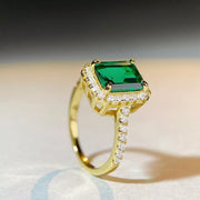 Top view of the rectangular green gemstone-style center and bright halo.