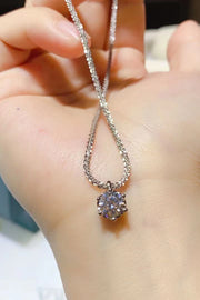 Round clear-stone pendant necklace held over an open hand