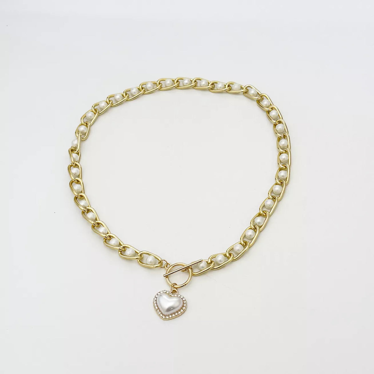 Chunky pearl chain necklace and heart pendant laid flat
