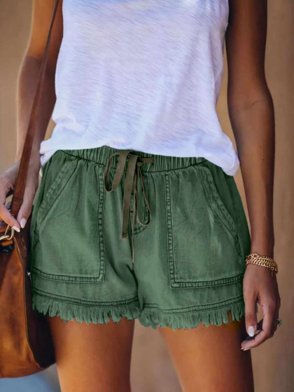 Green drawstring denim shorts with front patch pockets and frayed hems