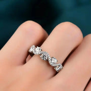 Floral moissanite band worn on a finger, shown close up.