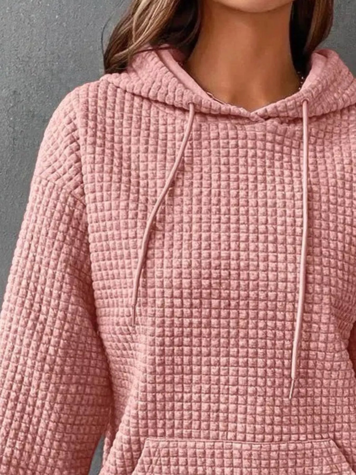 Close-up of pink textured hoodie fabric and drawstrings