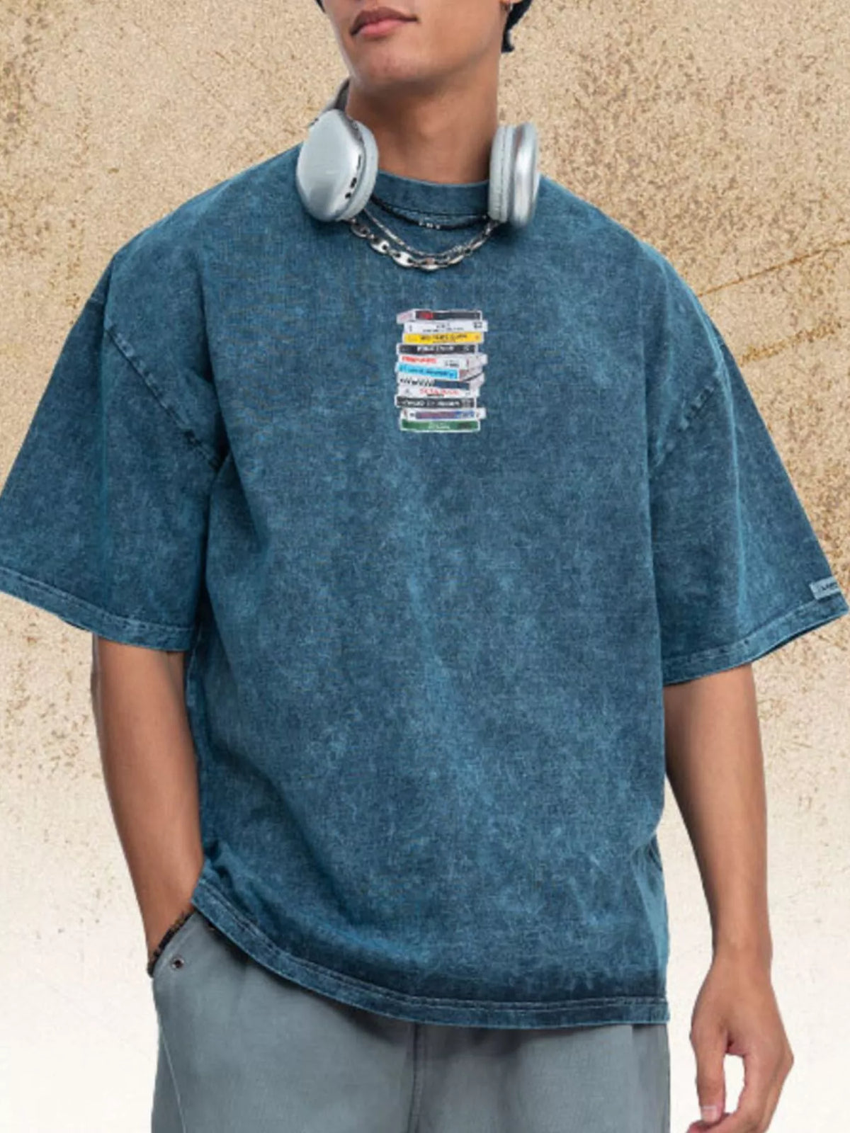 Model wearing a blue vintage-wash T-shirt with a small cassette graphic