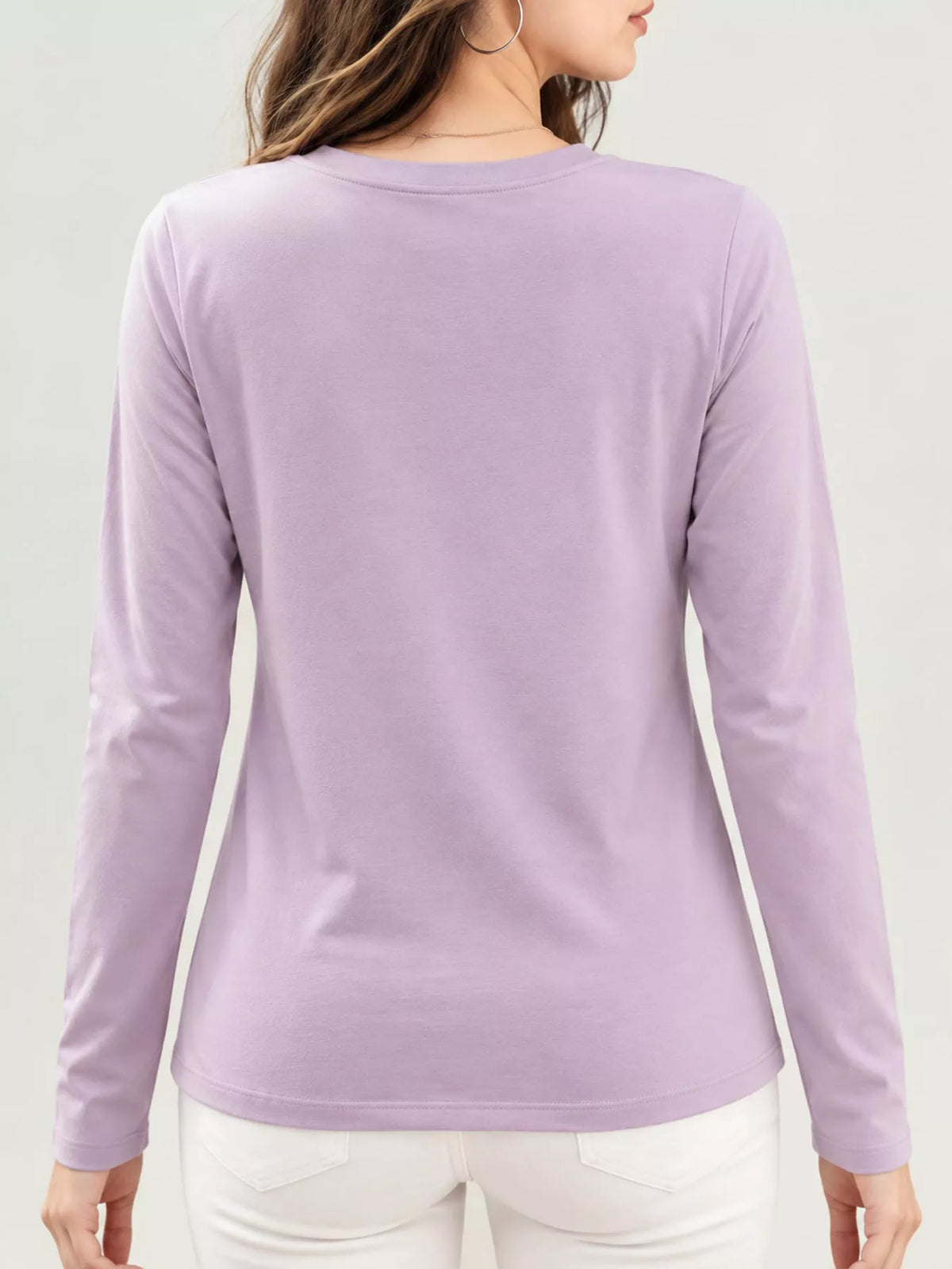 Back view of lavender long-sleeve T-shirt worn with white pants.