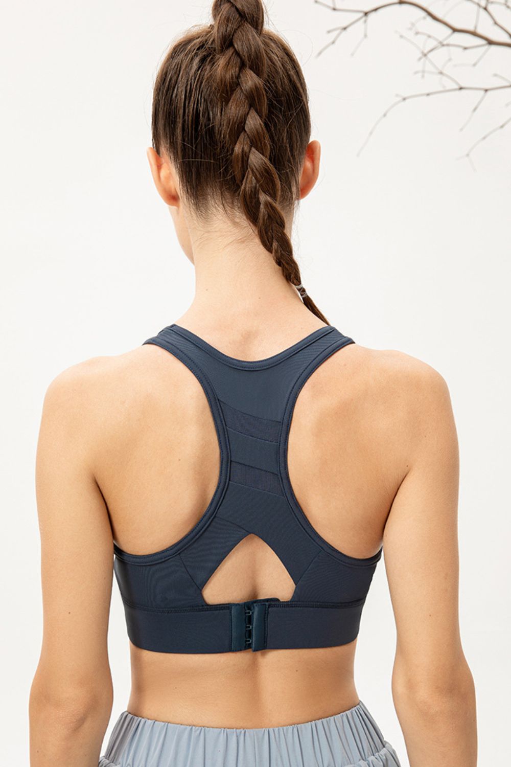 Back view of navy racerback sports bra with keyhole opening and hook closure