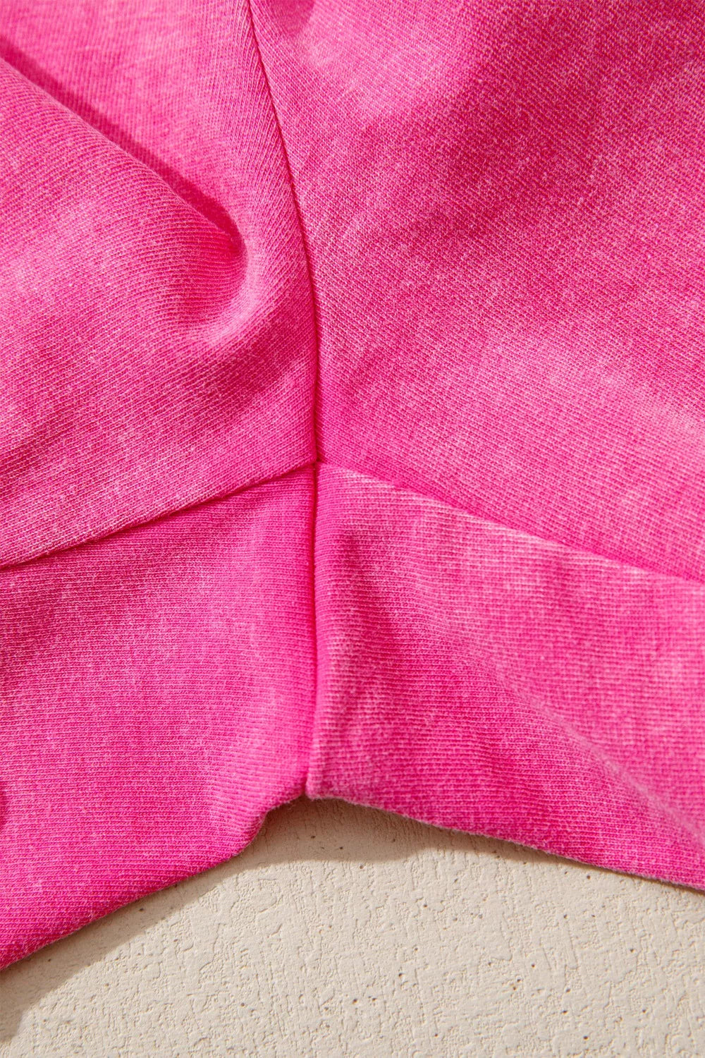 Close-up of pink shorts fabric and stitched seams