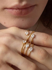 Gold-tone triple-layer ring displayed on textured surface