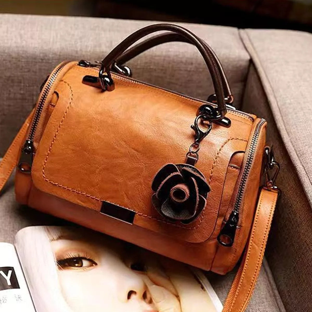 Tan flap bag with flower ornament viewed from above at an angle