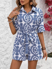 Women's blue-and-white printed romper, front view with hand at waist