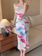 Model wearing a pink and blue watercolor-print midi dress with a ruched waist.