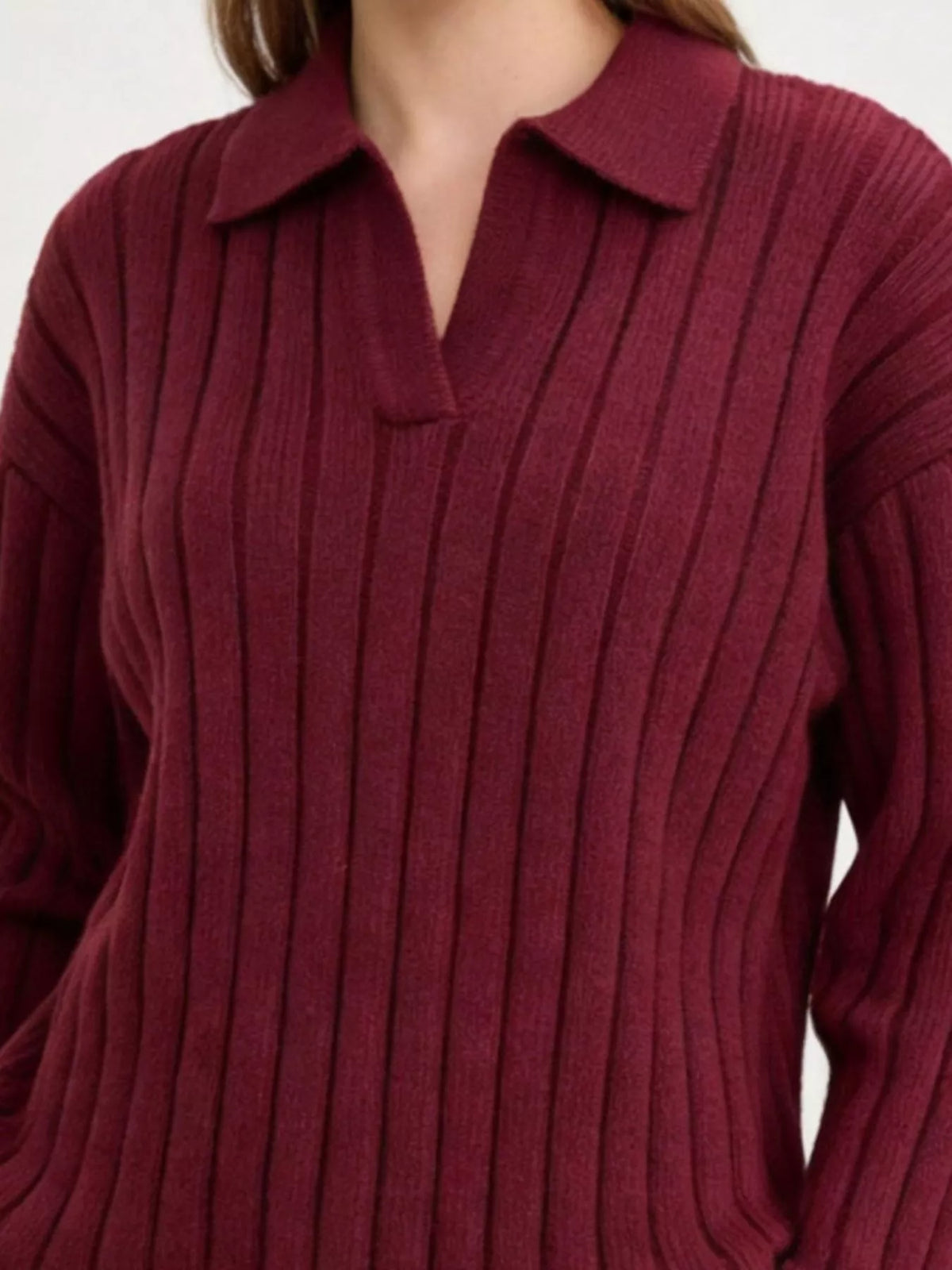 Close view of burgundy sweater's collar and ribbed knit pattern