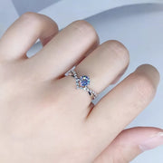 Blue rectangular center-stone ring with a pavé-set silver band, shown on a hand.