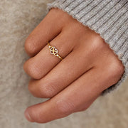 Infinity-heart ring worn on a hand with a knit sleeve